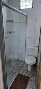 a bathroom with a toilet and a glass shower at Chalés Mirante da Lua Chalé 4 in Cavalcante
