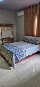 a bedroom with a bed with a blue and white blanket at Chalés Mirante da Lua Chalé 4 in Cavalcante