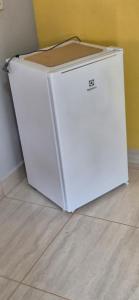 a white refrigerator sitting on the floor next to a wall at Chalés Mirante da Lua Chalé 4 in Cavalcante