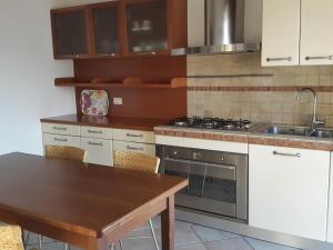 una cucina con piano cottura e tavolo in legno di Appartamento Valparadiso a Negrar