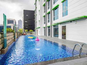a swimming pool with a pink toy in the middle of a building at ibis Styles Singapore Albert in Singapore