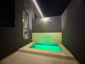 a bathroom with a swimming pool with a mirror at شاليهات رون الفندقية in Medina