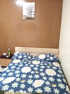 a bedroom with a bed with a blue and white comforter at Casabella in Dakar