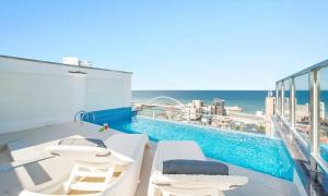 a balcony with a swimming pool and the ocean at Gangneung Skaria Poolvilla in Gangneung