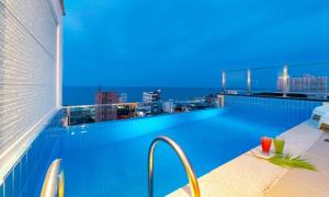 a swimming pool with a view of the city at night at Gangneung Skaria Poolvilla in Gangneung