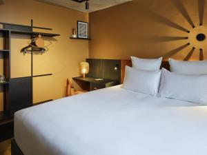 a bedroom with a large bed with white pillows at Tribe Paris Saint Ouen in Saint-Ouen +89 photos