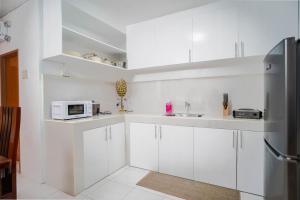 a white kitchen with white cabinets and a microwave at The P Residences in San Agustin