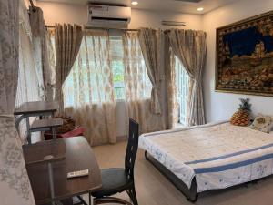 a bedroom with a bed and a chair and a window at Cactos Pool & Palms Local Stay in Ho Chi Minh City +25 photos