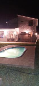 a swimming pool in front of a house at night at Villa Luna in Chincha