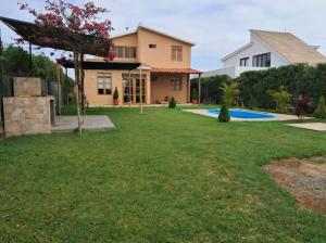 a yard with a house and a swimming pool at Villa Luna in Chincha