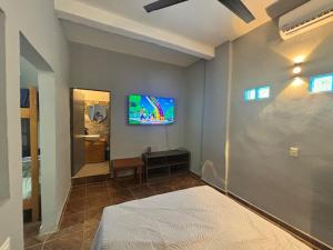 a bedroom with a bed and a tv on the wall at Private Pool Villa Near Bacalar Lagoon in Xul-Ha