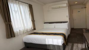 a bedroom with a large bed with a window at Airport Plaza Hotel in Tomisato