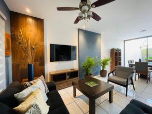 a living room with a couch and a tv at Casa Fénix in Tepic
