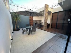 a patio with a table and chairs and an umbrella at Casa Fénix in Tepic