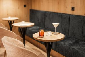 a room with a couch and two tables and chairs at Sporthotel Floralpina in Alpe di Siusi