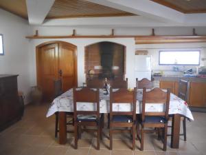 a kitchen with a dining room table and chairs at Windmill Hill in Cercal