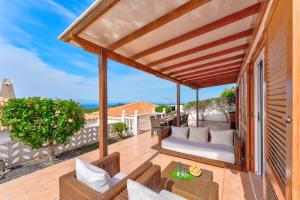 an outdoor patio with chairs and a table at Ocean View 3bedroom Villa with pool in Callao Salvaje