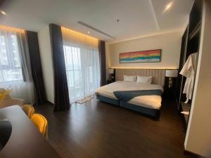 a bedroom with a bed in a room with windows at Sapphia Hạ Long in Ha Long