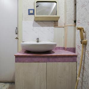 a bathroom with a sink and a tv on the wall at Sri Ganapathy Lodge in Coimbatore