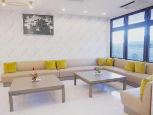 a living room with a couch and two tables at Airport Plaza Hotel in Tomisato