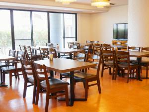 a room with tables and chairs and a flat screen tv at Airport Plaza Hotel in Tomisato