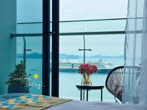 a bedroom with a view of a cruise ship in the water at Sapphia Hạ Long in Ha Long +19 photos