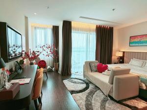 a bedroom with a bed and a desk and a couch at Sapphia Hạ Long in Ha Long