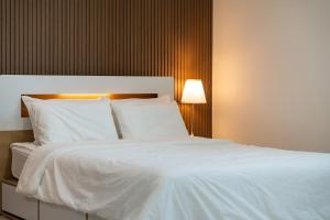 a large white bed with white sheets and pillows at 초음정 Luxury Hanok Style Villa with Private Garden in Gyeongju in Gyeongju