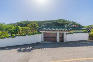 a building with a gate with a mountain in the background at 초음정 Luxury Hanok Style Villa with Private Garden in Gyeongju in Gyeongju