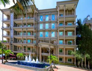 a building with a fountain in front of it at Fountain Palace Hotel & Suites in Kampala