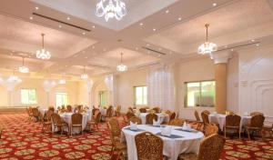 a banquet hall with tables and chairs and chandeliers at Fountain Palace Hotel & Suites in Kampala +72 photos