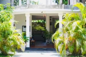 a house with palm trees in front of it at Grace Inn in Kalkudah