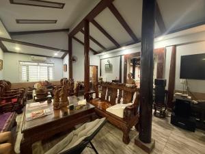 a living room with wooden furniture and a tv at Cactos Pool & Palms Local Stay in Ho Chi Minh City