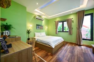 a green bedroom with a bed and a window at Harmony Stay - Ben Thanh Market in Ho Chi Minh City