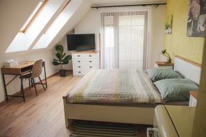 a bedroom with a bed and a desk and a television at Penzion Pod Hradem in Potštejn