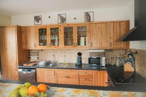 a kitchen with wooden cabinets and a black counter top at Penzion Pod Hradem in Potštejn
