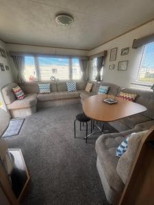 a living room with a couch and a table at Green Goddess in Skipsea