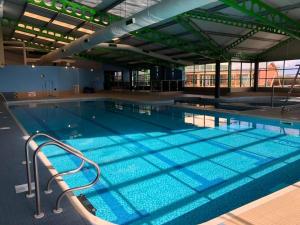 a large swimming pool with blue water at Green Goddess in Skipsea
