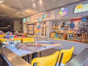 a restaurant with tables and yellow chairs and signs at Green Goddess in Skipsea