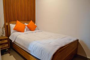 a bed with orange pillows on it in a room at Ricefield View 2 BR villa near Canggu in Dalung