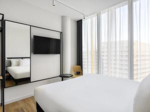 a bedroom with a white bed and a large mirror at ibis Budapest Stadium in Budapest +76 photos