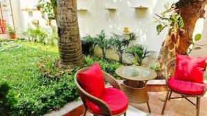 a patio with chairs and a table and a tree at Parijat Heritage in Bhubaneshwar