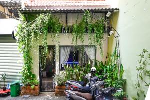 a motorcycle parked in front of a building with plants at Harmony Stay - Ben Thanh Market in Ho Chi Minh City