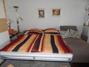シュルッフゼーにあるDomicil Schluchseeのカラフルなストライプ掛け布団付きのベッド1台