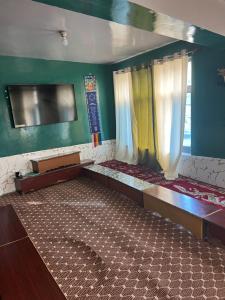 an empty room with two beds and a window at Bittu Homestay in Kaza