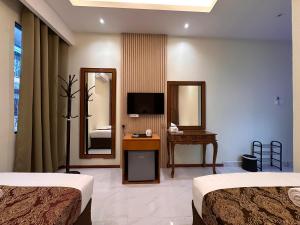 a hotel room with two beds and a mirror at Grand Luxury Hotel Semporna in Semporna