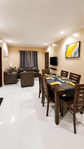 a dining room with a table and chairs and a couch at Block 23 - Dogwood in Bacolod