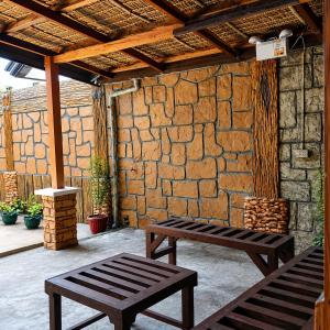 a patio with two benches and a stone wall at Block 23 - Dogwood in Bacolod