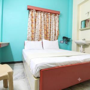 a bed with a red headboard in a room at Sri Ganapathy Lodge in Coimbatore