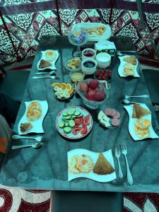 a table topped with plates of food on top at Kochmon guesthouse in Naryn
